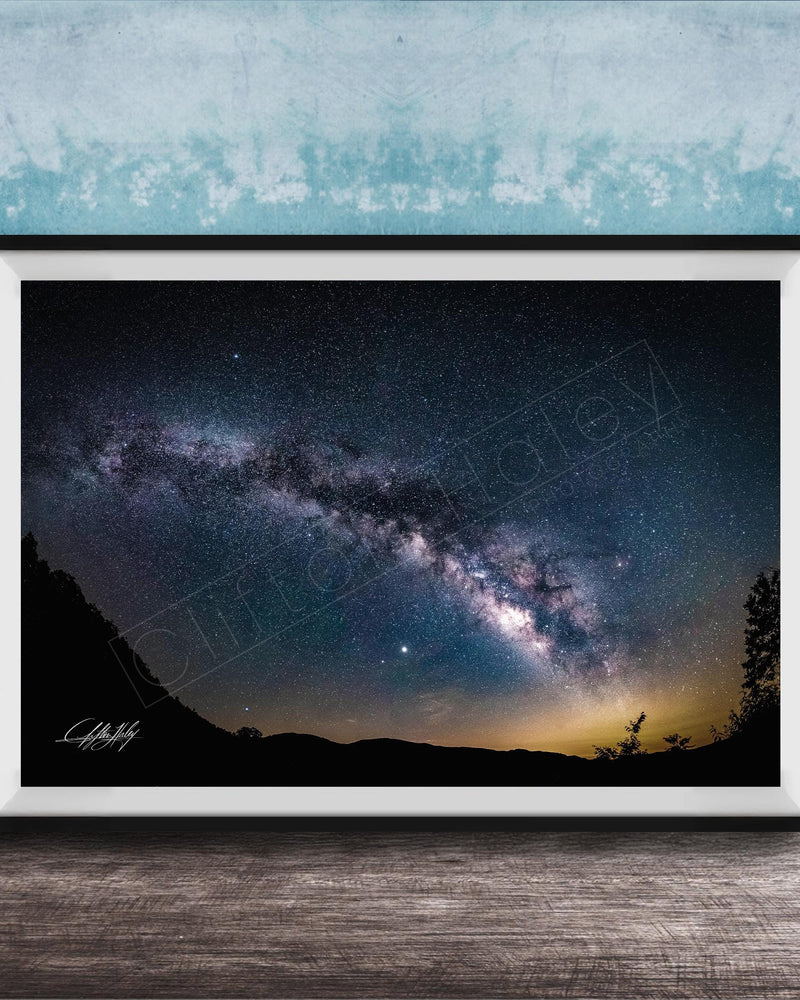 The image is a framed photograph of a night sky with a view of the Milky Way galaxy.