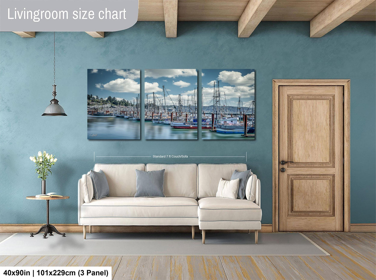 The image is a living room with a large painting of a harbor scene hanging on the wall. The painting is divided into three panels, depicting boats and a cloudy sky. The room has a white sofa and a wooden door, creating a cozy and inviting atmosphere.