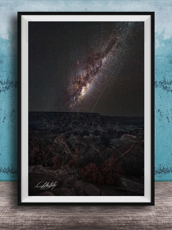 The image is a framed photograph of a night sky with a distant galaxy, set against a dark background.