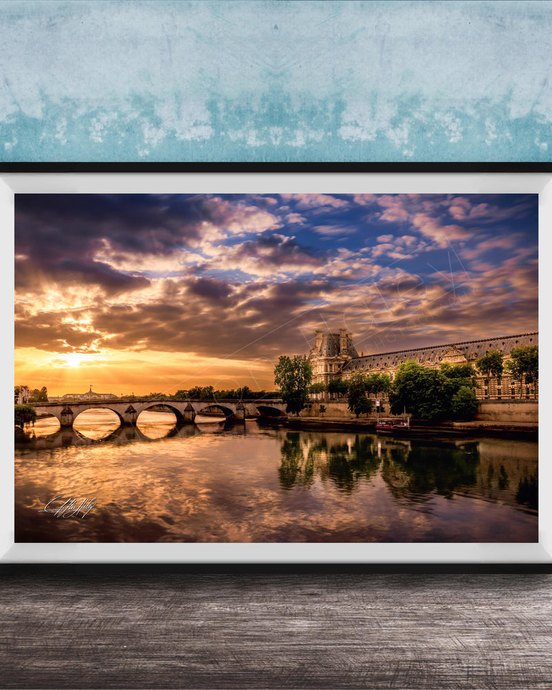 a picturesque scene of a river with a bridge, set against a stunning sunset sky with clouds.
