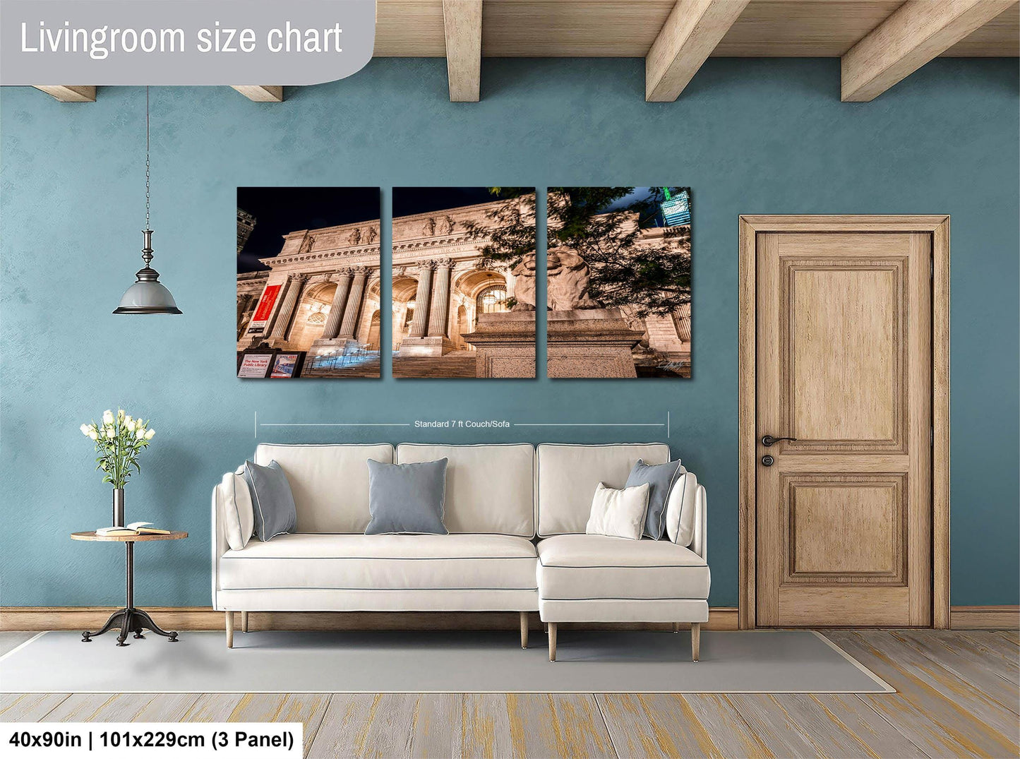 The image is a living room with a white sofa and a wooden door. Above the sofa, there is a large wall art collage depicting a building at night. The wall art is framed and hangs on the wall. The living room has a blue wall and a wooden floor.