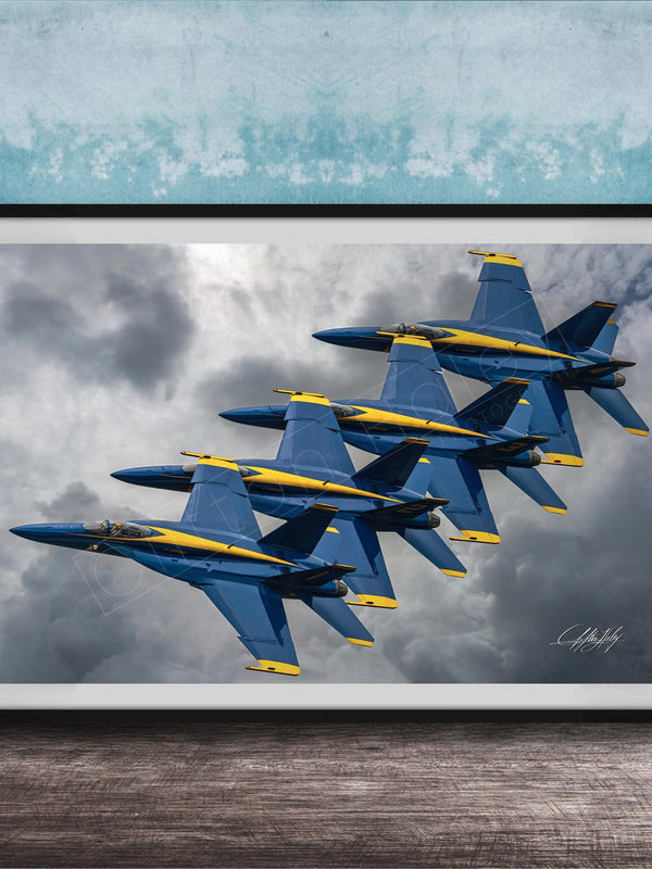 A framed photograph of four blue and yellow fighter jets flying in formation against a cloudy sky.