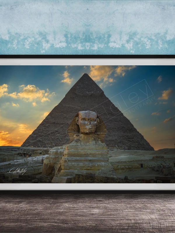 a large, ancient Egyptian pyramid with a sphinx statue in the foreground, set against a colorful sunset sky.