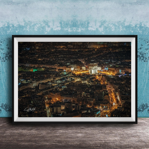 The image is a framed aerial view of a city at night, showcasing the illuminated buildings and streets below.