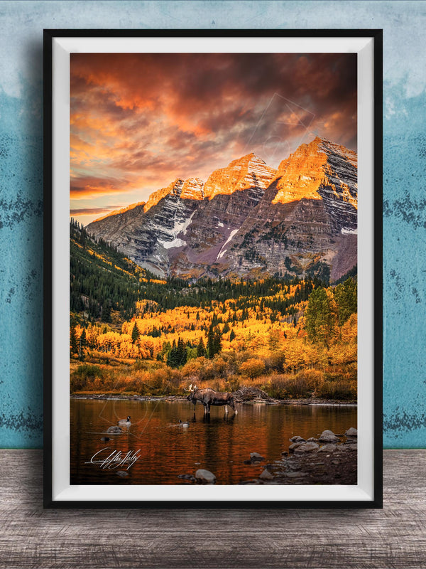 a breathtaking mountain landscape with a vibrant sunset sky, casting a warm glow over the snow-capped peaks and the surrounding forest.