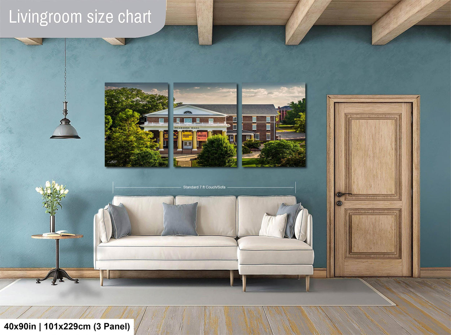 The image is a living room with a large white sofa, a wooden door, and a wall with a large painting depicting a building.