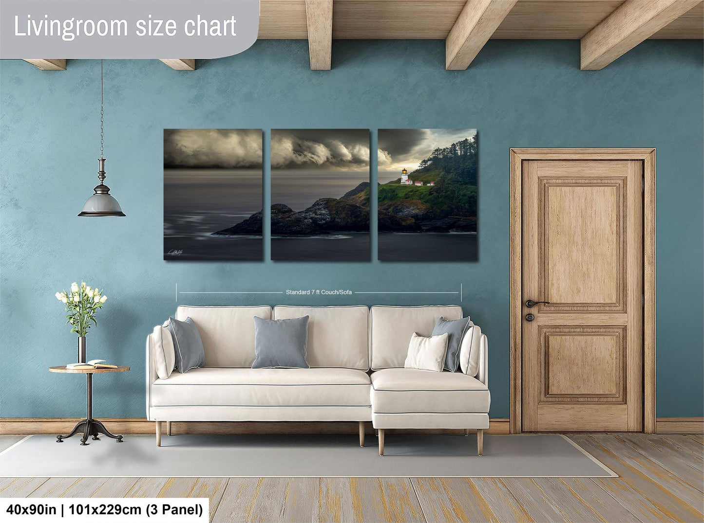 The image is a living room with a large white sofa, a wooden door, and a painting of a coastal landscape above the sofa.