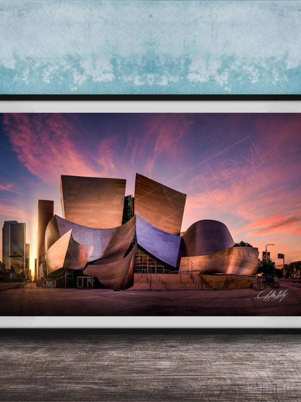 A framed photograph of the Guggenheim Museum in Bilbao, Spain, at sunset, with the distinctive curved architecture of the building illuminated against a colorful sky.