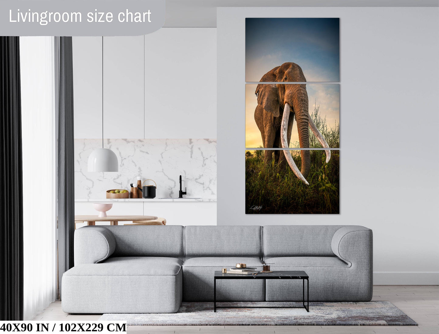 The image is a living room with a gray sofa, a coffee table, and a large painting of an elephant in the background.