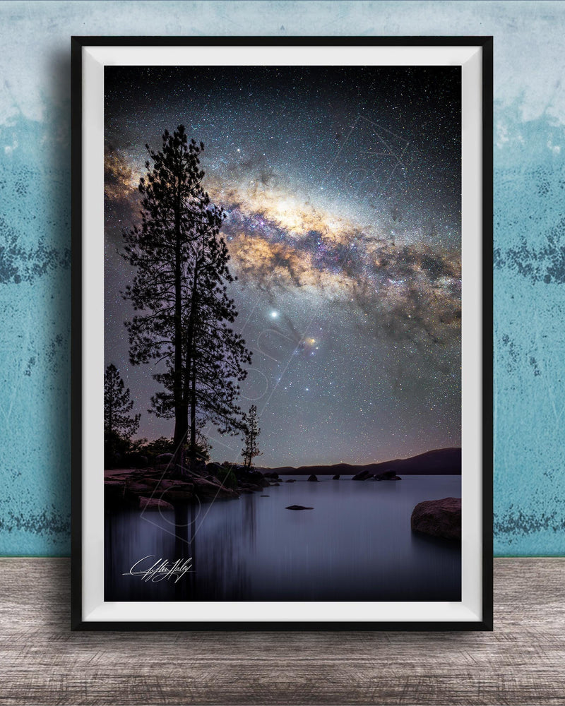 The image is a framed photograph of a serene night scene with a starry sky, a lake, and a forest.