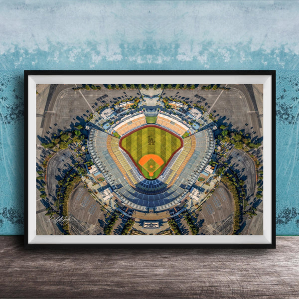 The image is an aerial view of a baseball stadium, featuring a large field surrounded by parking lots and other structures.