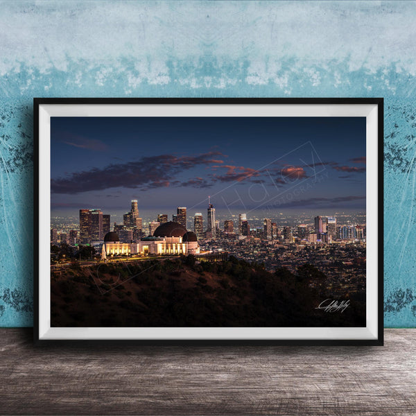 A framed photograph of the Los Angeles skyline at night, with the iconic Griffith Observatory prominently visible in the foreground.