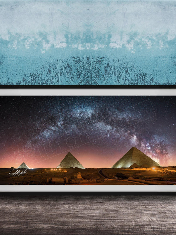 a framed photograph of the pyramids of Giza at night, with the stars visible in the sky above the ancient structures.