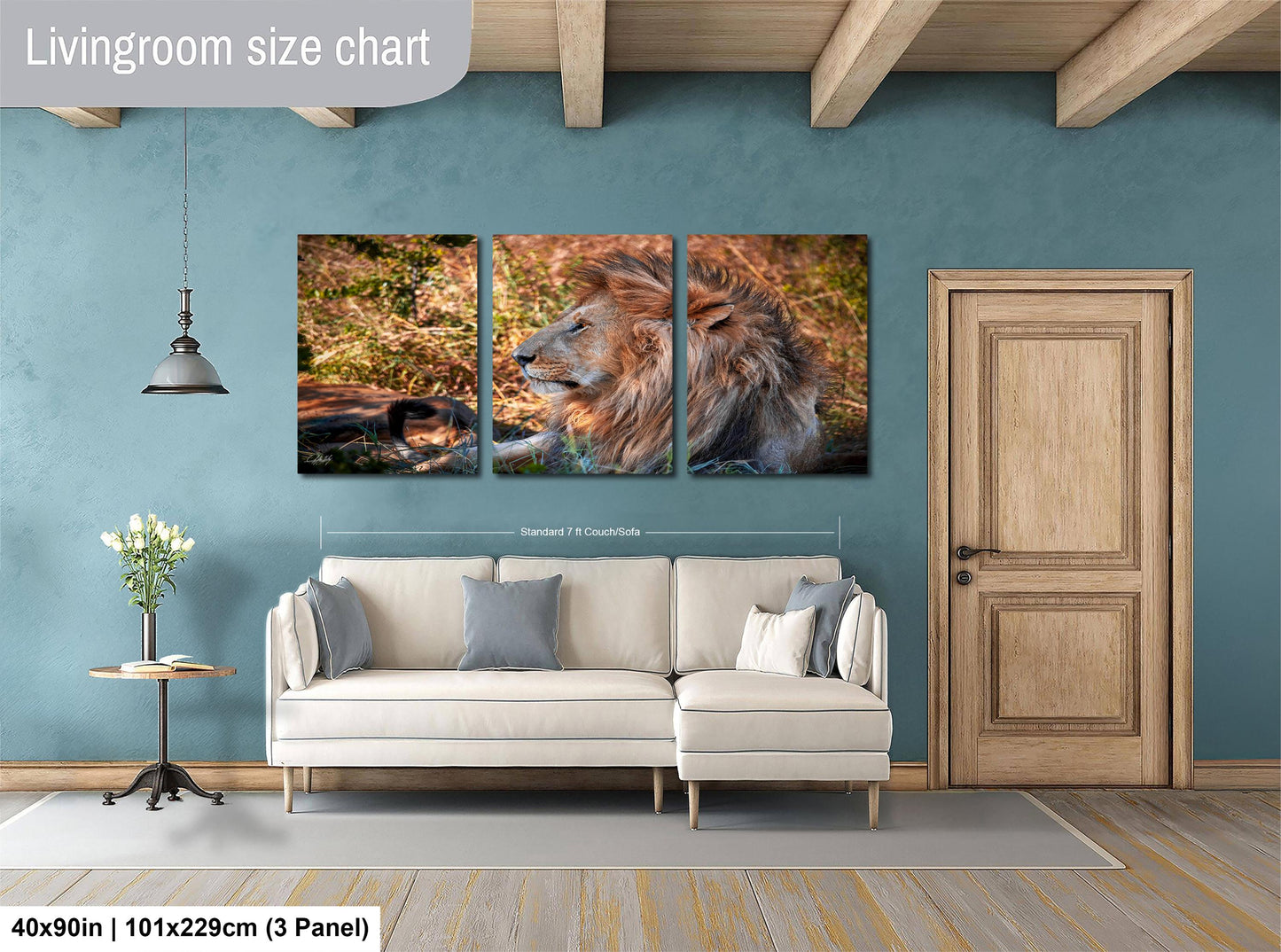 The image is a living room with a large wall art depicting a lion in a natural setting. The wall art is divided into three panels, with the largest panel showing the lion in profile. The room has a white sofa, a wooden door, and a small table with a vase of flowers. The wall art is approximately 40 inches wide and 101.29 cm tall, with a 3-panel layout.