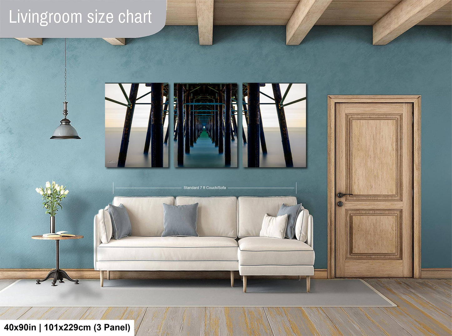 The image is a living room with a large white sofa, a wooden door, and a wooden beam ceiling. Above the sofa, there is a large living room size chart that provides dimensions for the furniture.