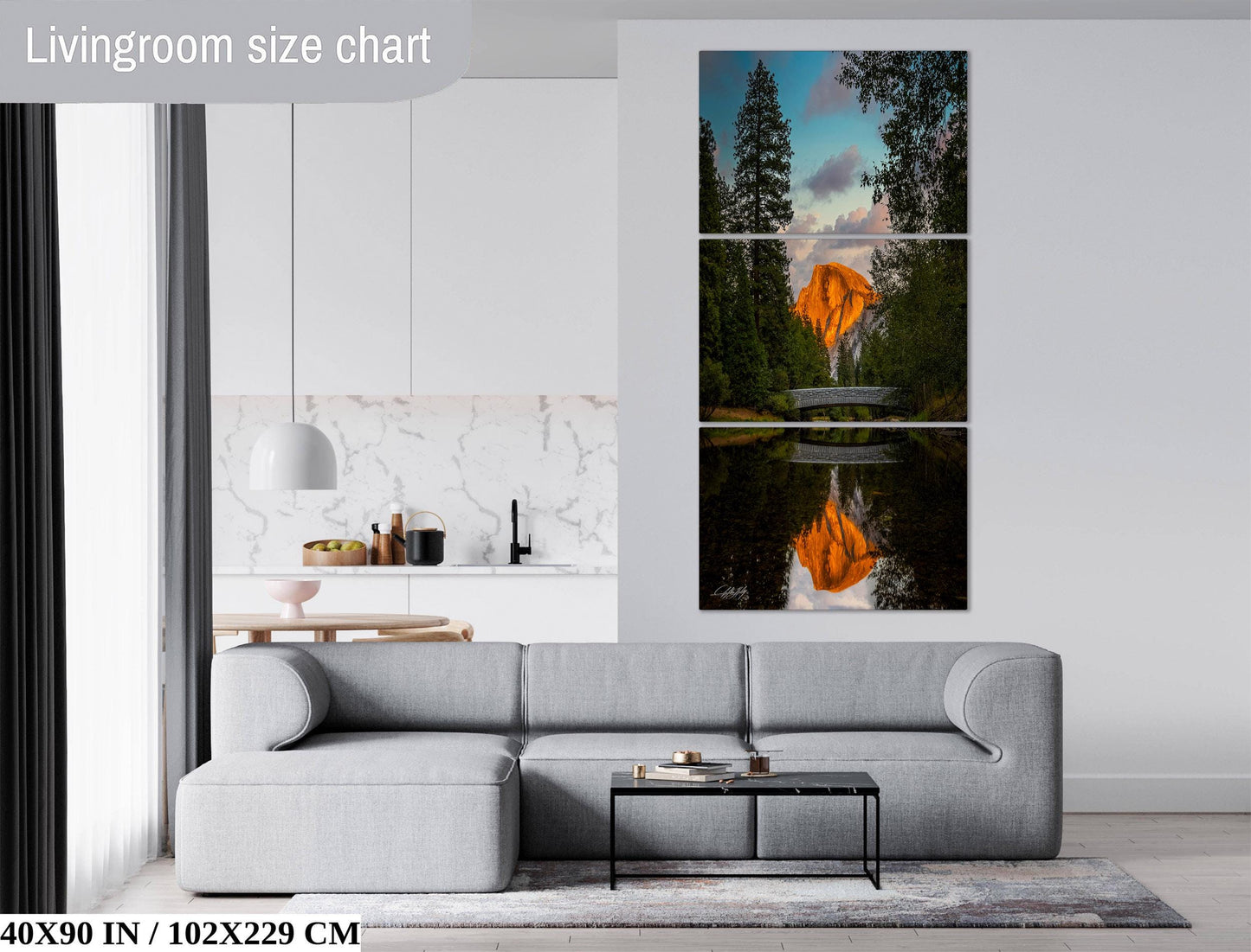The image is a living room with a gray sofa, a coffee table, and a large painting of a mountain landscape with a waterfall and trees.