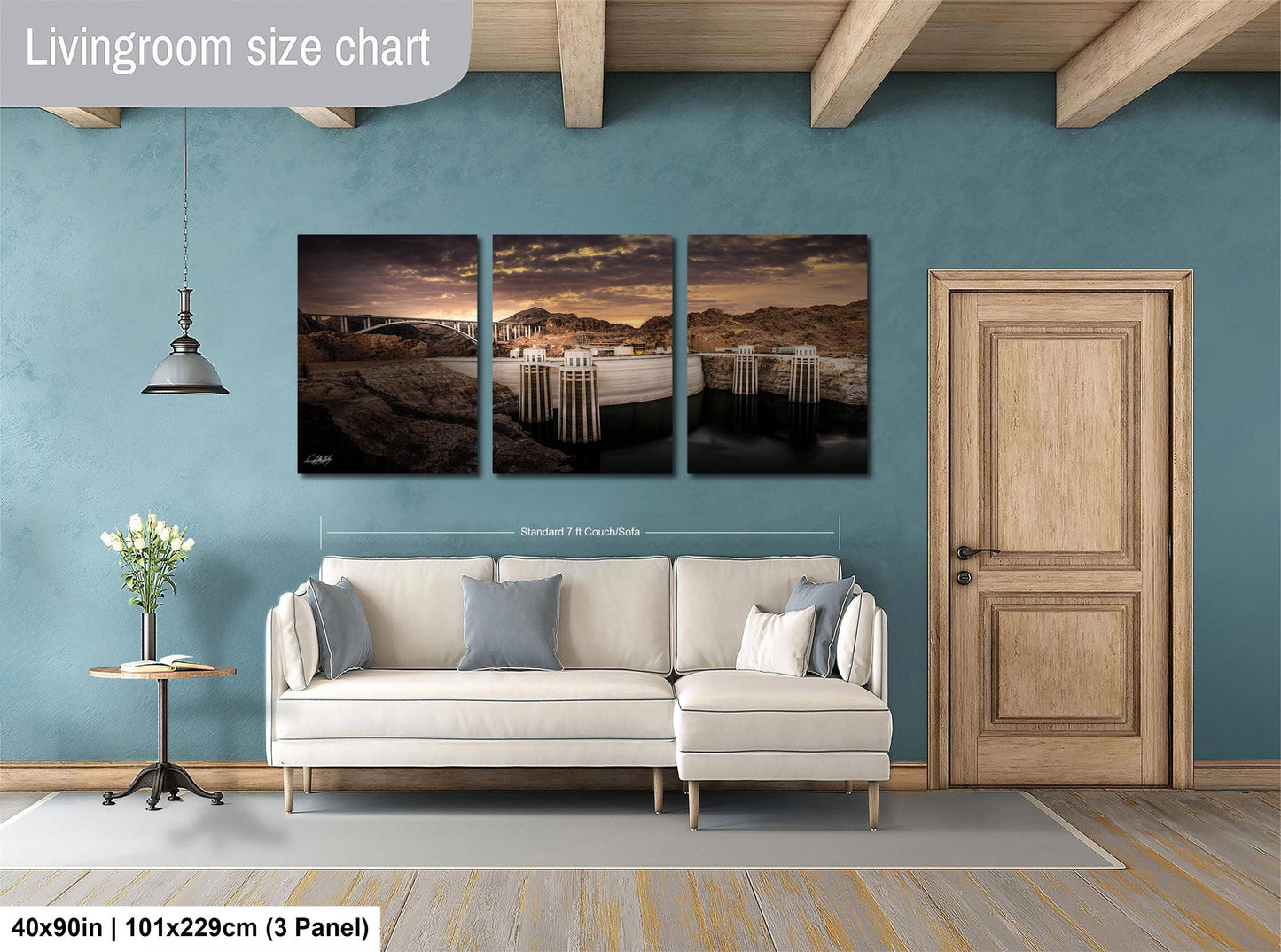 The image is a living room with a white sofa and a wooden door. Above the sofa, there is a triptych of landscape paintings depicting a serene scene with a bridge, mountains, and a sunset. The paintings are framed and hung on the wall, creating a harmonious and visually appealing interior design.