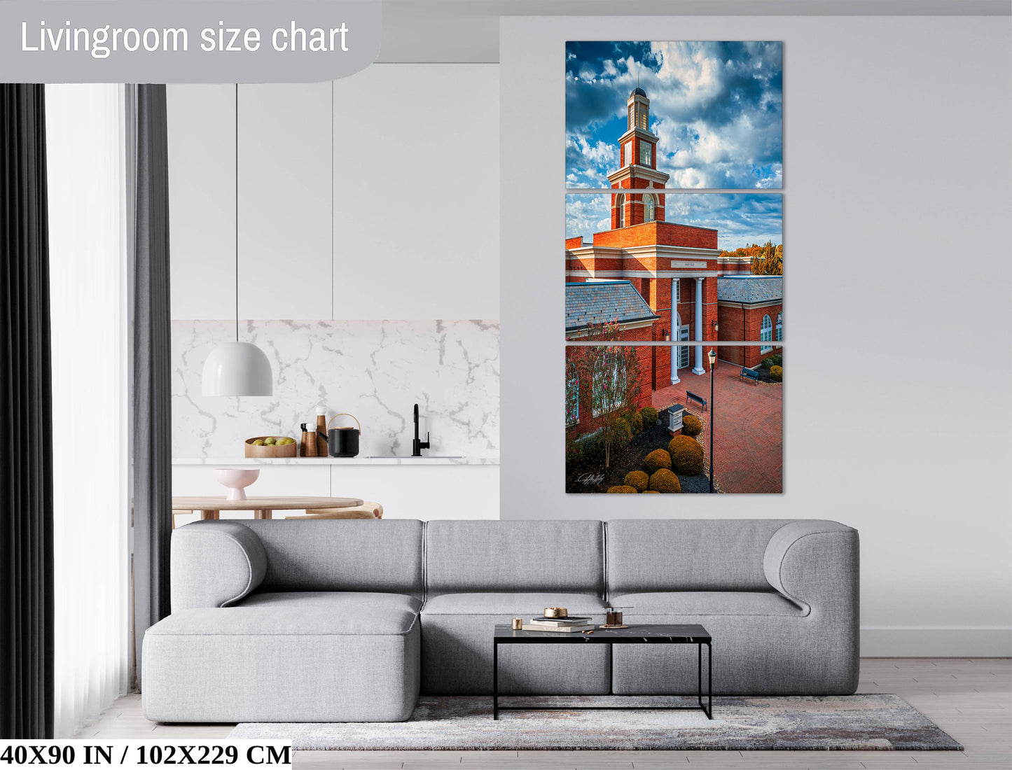 The image is a living room with a gray sofa, a coffee table, and a large painting of a building with a clock tower on the wall.