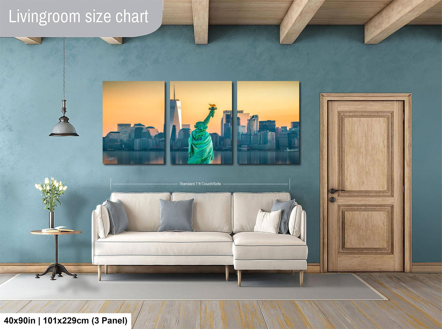The image is a living room with a large wall art depicting the Statue of Liberty in New York City. The wall art is divided into three panels, each showing a different angle of the iconic landmark. The living room has a white sofa and a wooden door, creating a cozy and inviting atmosphere.