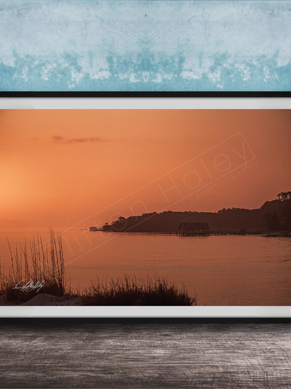 a serene sunset over a body of water, with a small island visible in the distance.