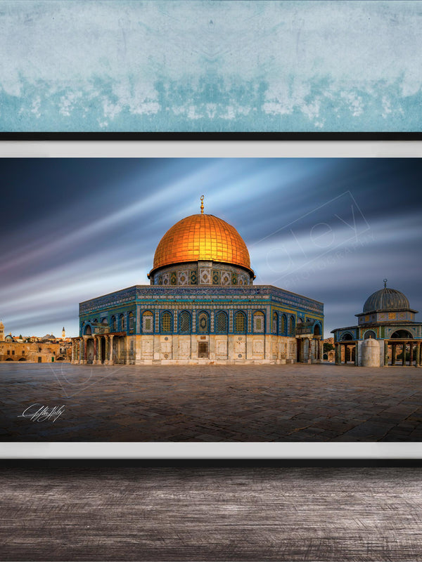 a large, ornate building with a golden dome, possibly a mosque or a significant historical structure, set against a blue sky with wispy clouds.