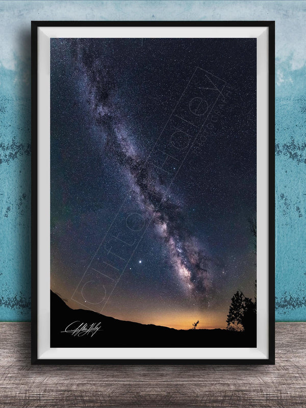 The image is a framed photograph of a night sky with the Milky Way galaxy, a stunning celestial display.