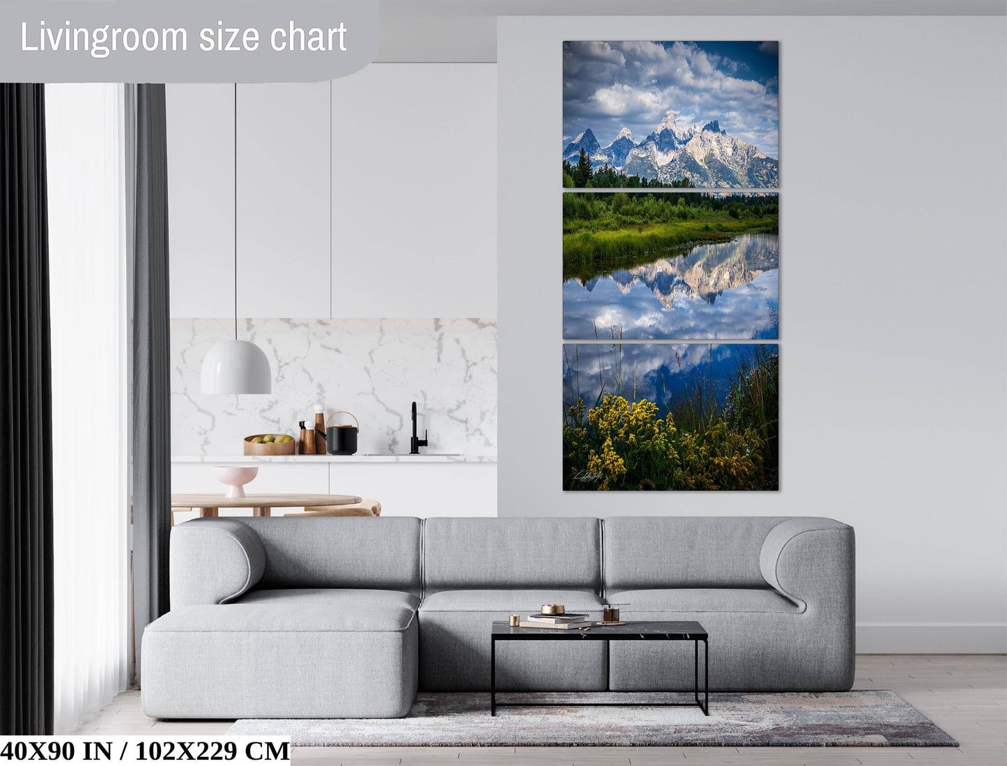 The image is a living room with a gray sofa, a coffee table, and a large landscape painting depicting a mountain range and a lake.