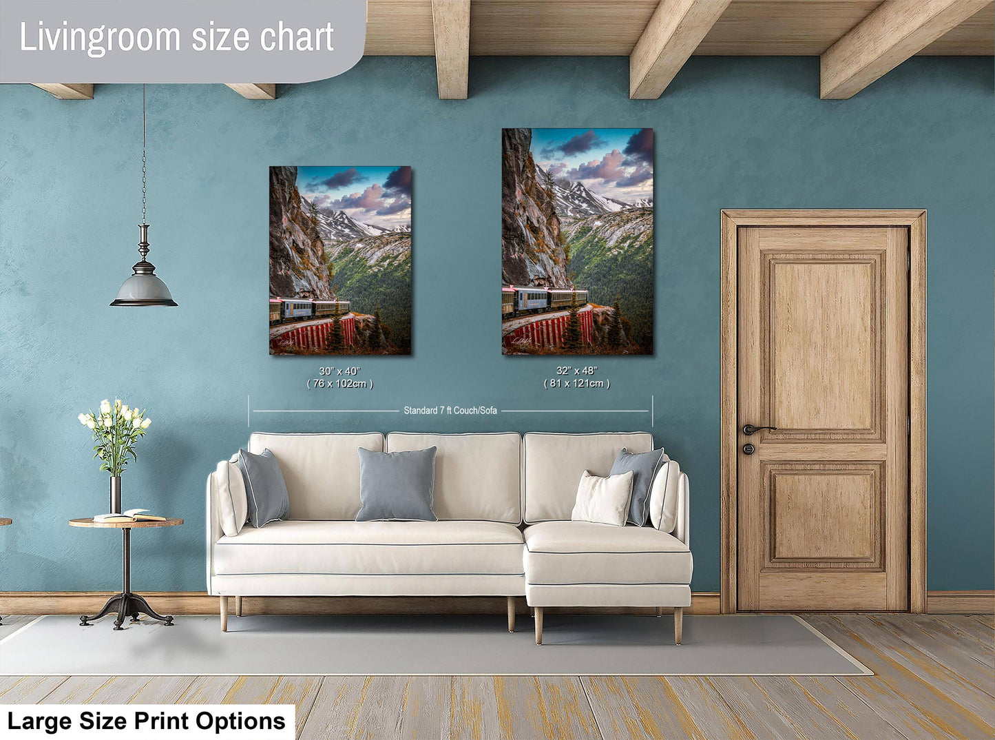 a living room with a white sofa, a wooden door, and two framed pictures of a mountain landscape hanging on the wall.