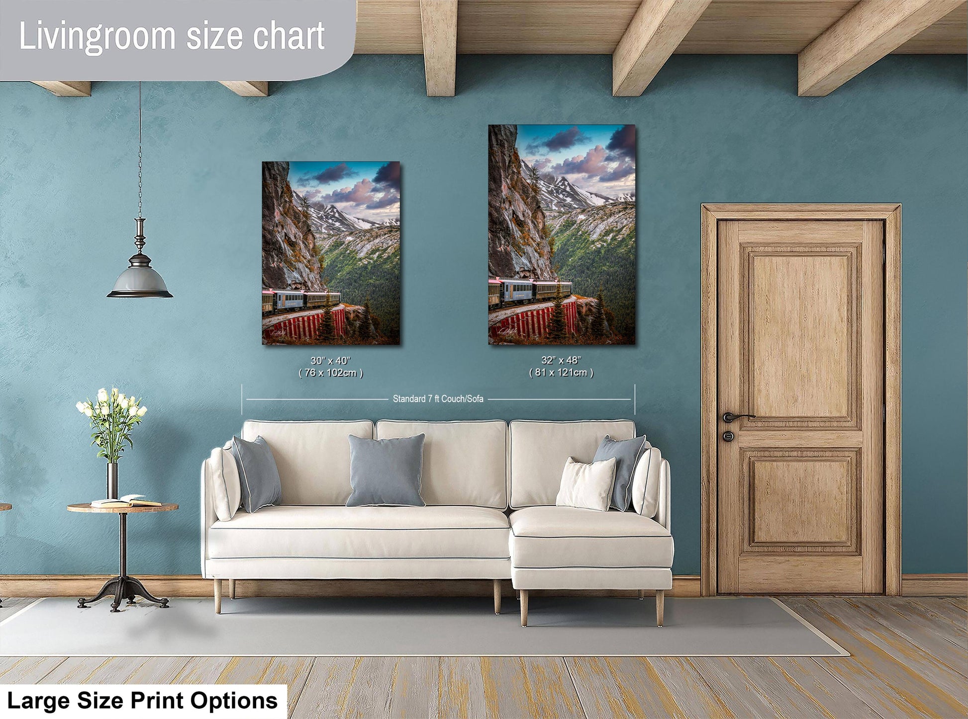 a living room with a white sofa, a wooden door, and two framed pictures of a mountain landscape hanging on the wall.