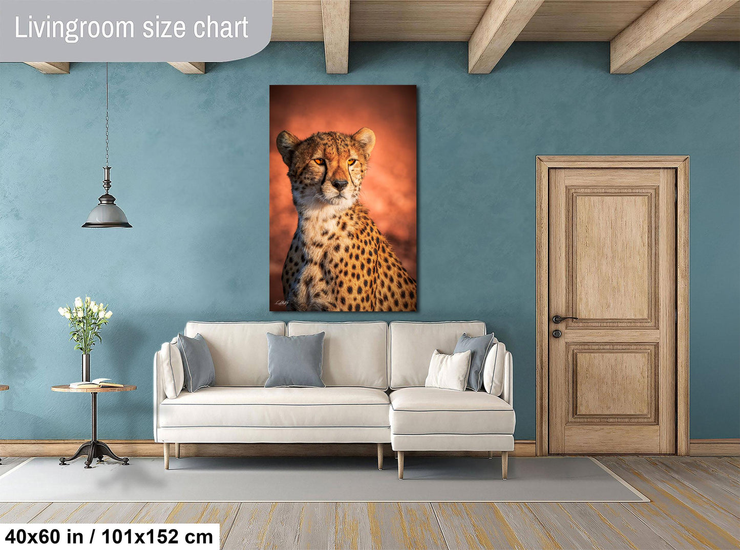 a living room with a large white sofa, a wooden door, and a framed photograph of a cheetah on the wall.