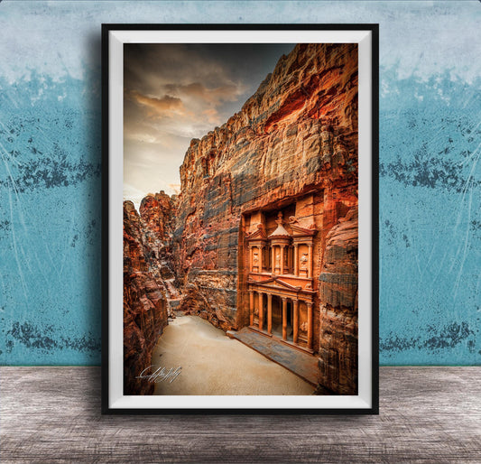 a carved doorway in a canyon, with a dramatic sky in the background.