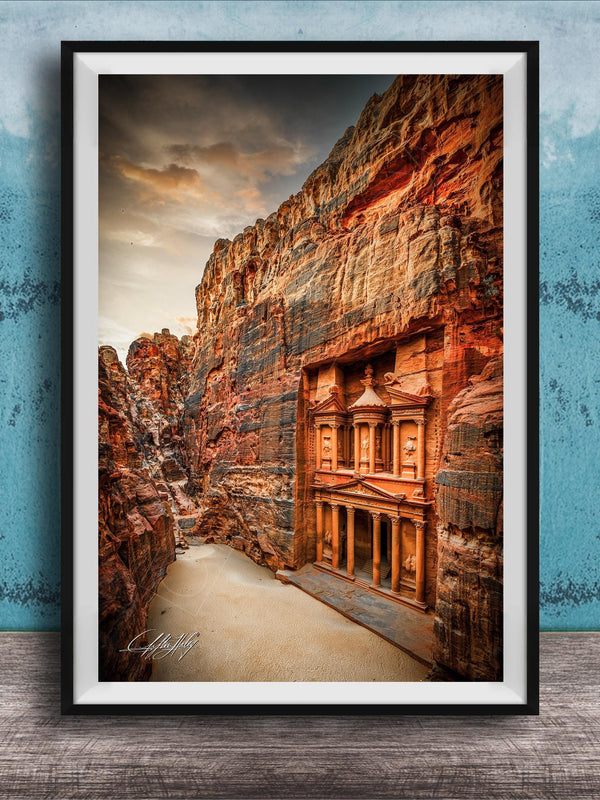 a carved doorway in a canyon, with a dramatic sky in the background.