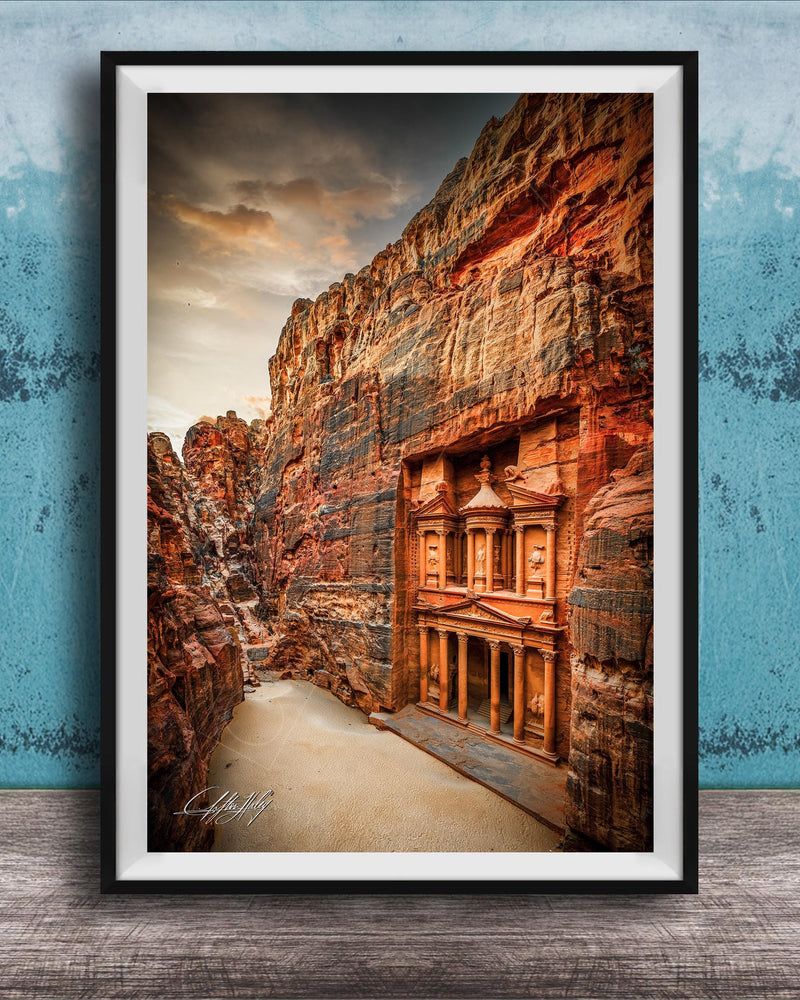 a carved doorway in a canyon, with a dramatic sky in the background.