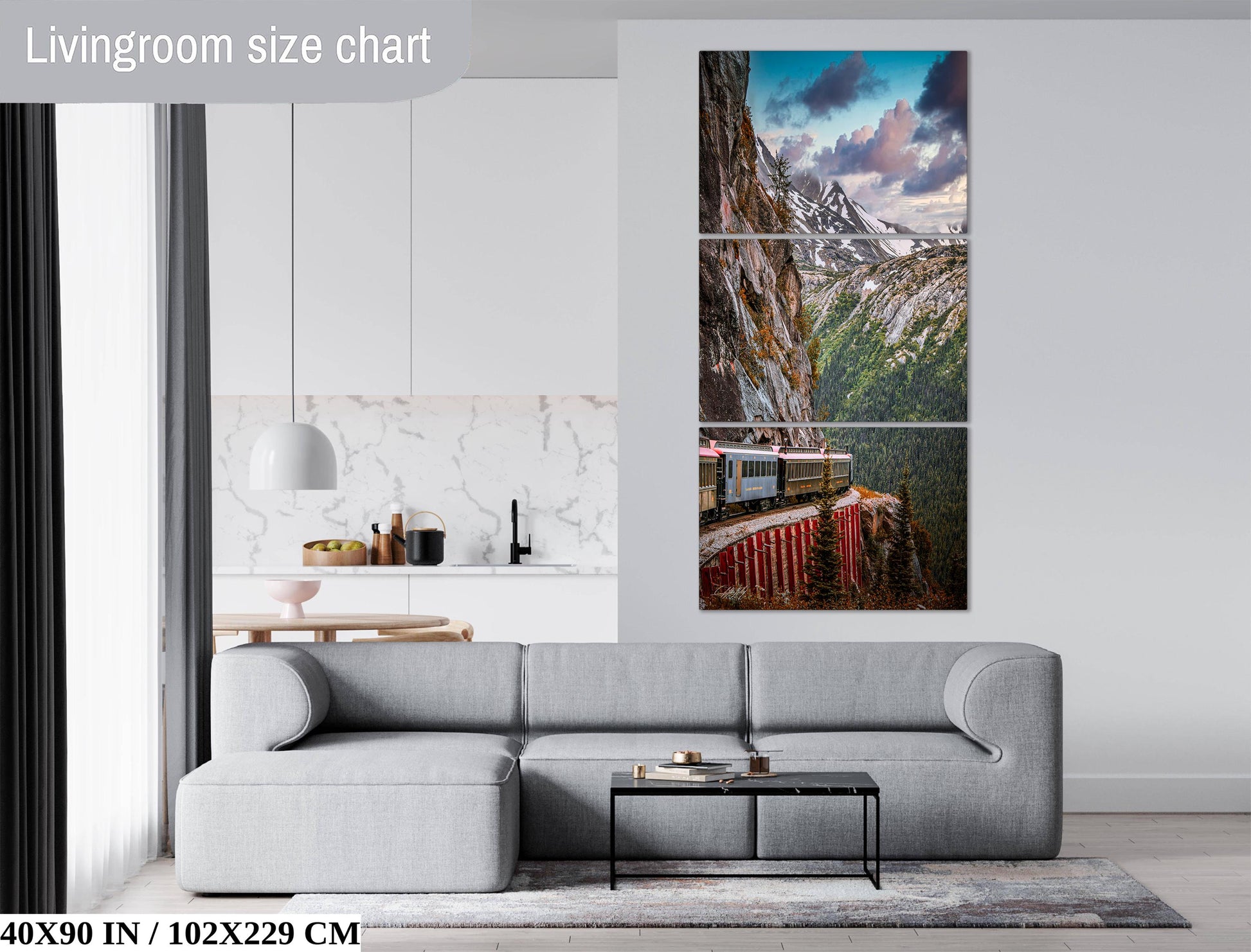 The image is a living room with a gray sofa, a coffee table, and a large wall art depicting a train on a mountain.