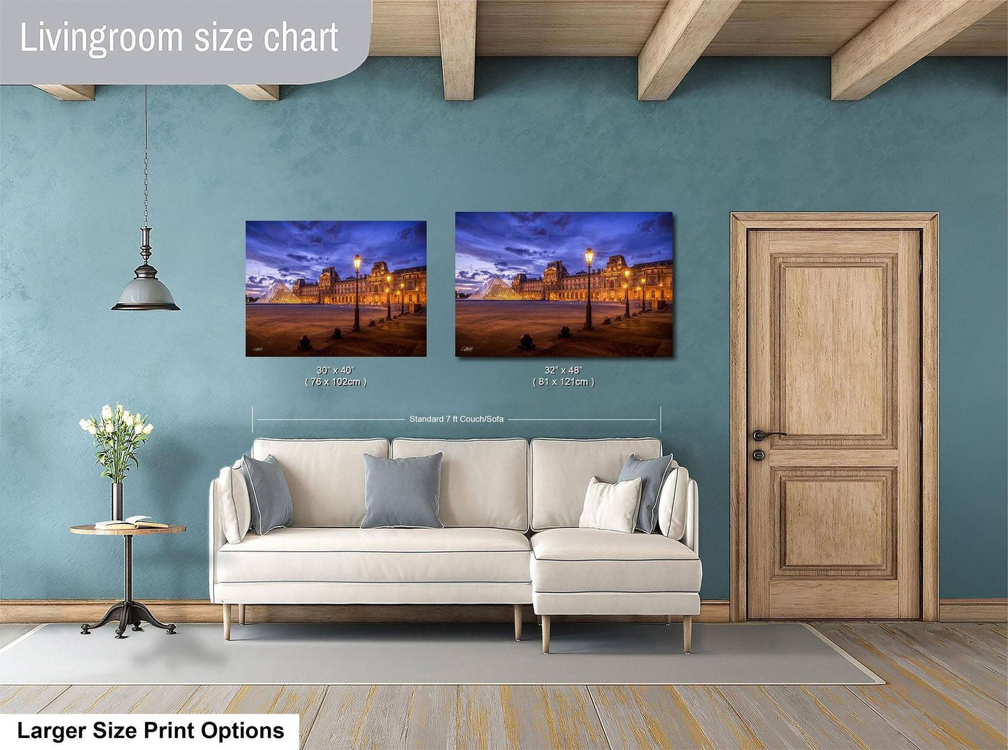 a living room with a white sofa and a wooden door. Above the sofa, there are two framed pictures hanging on the wall, depicting a cityscape at night. The living room has a blue wall and a wooden ceiling.