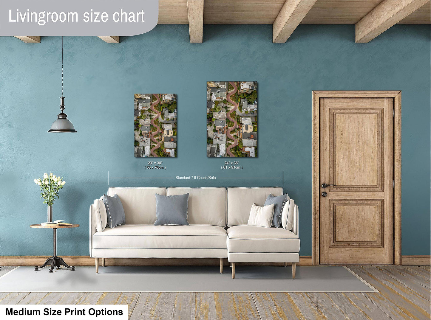 a living room with a white sofa, a wooden door, and a painting of a city street on the wall.