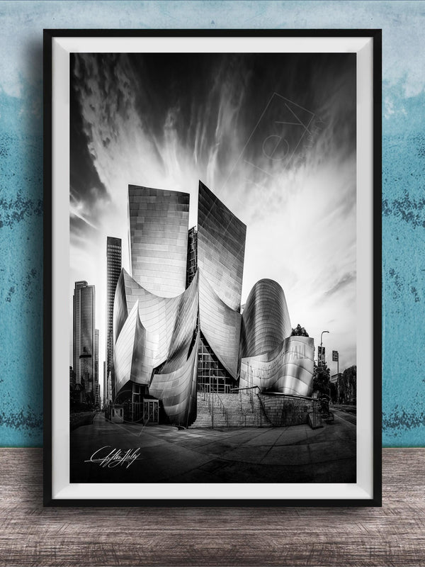 A black and white photograph of a modern, curved building with a distinctive architectural design, set against a cloudy sky.