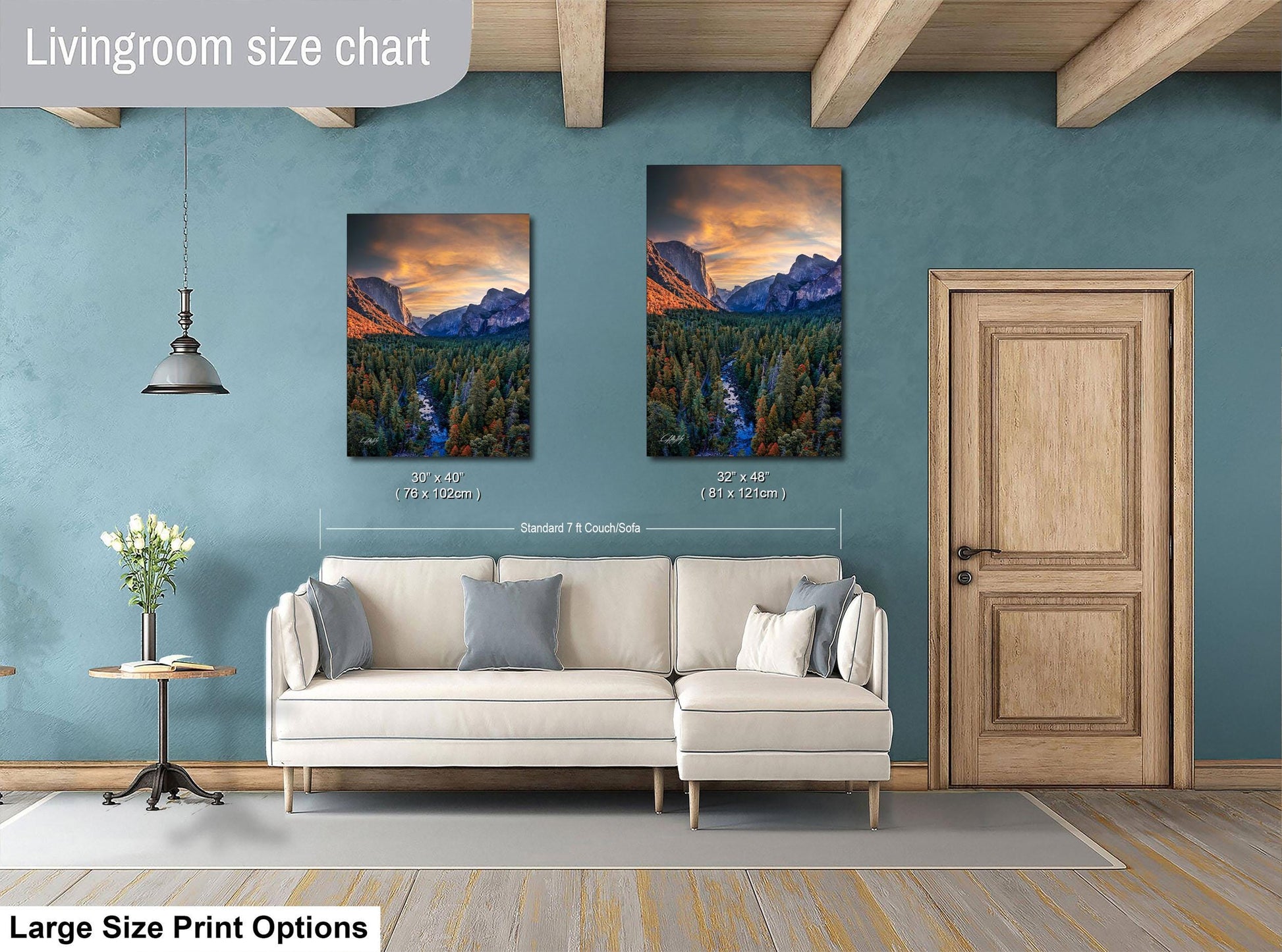 a living room with a white sofa and a wooden door. Above the sofa, there are two framed landscape paintings depicting mountains and forests. The paintings are of similar size, and the wall behind them is painted in a light blue color.