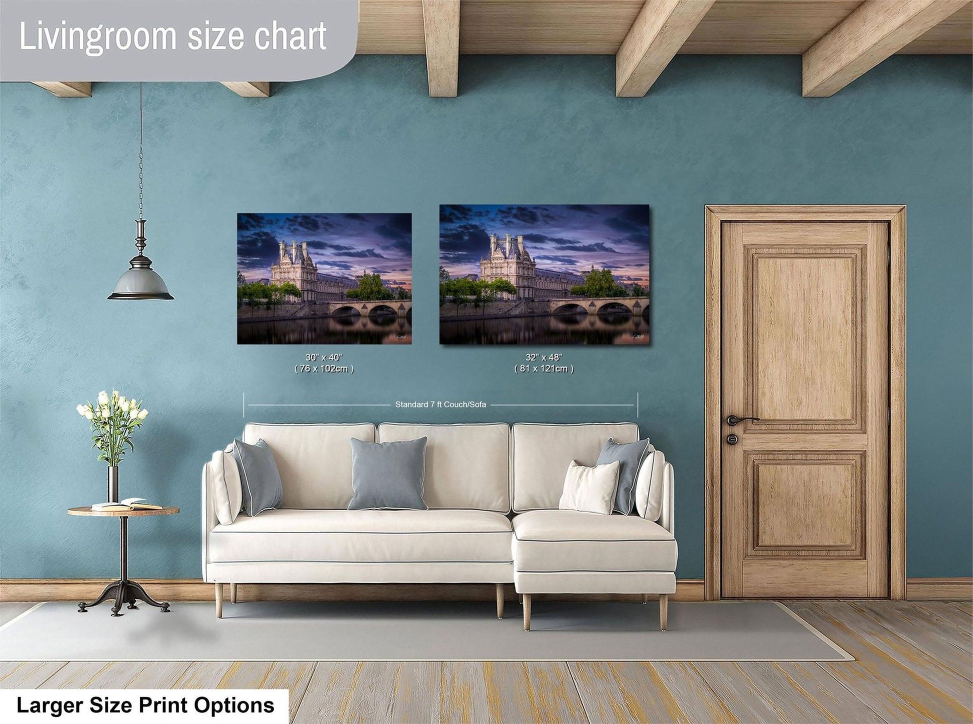 a living room with a white sofa and a wooden door. Above the sofa, there are two framed pictures of a cityscape, likely taken at night. The living room has a blue wall and a wooden ceiling.