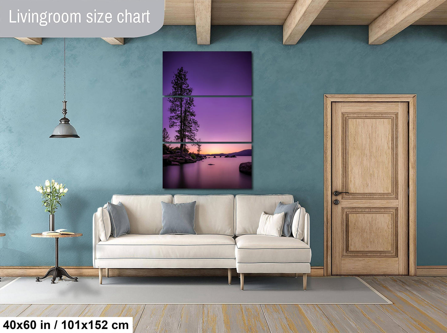 a living room with a large, colorful painting of a sunset over a lake hanging on the wall. The painting is framed in a wooden frame and is the focal point of the room. The living room is furnished with a white sofa and a wooden door, creating a cozy and inviting atmosphere.