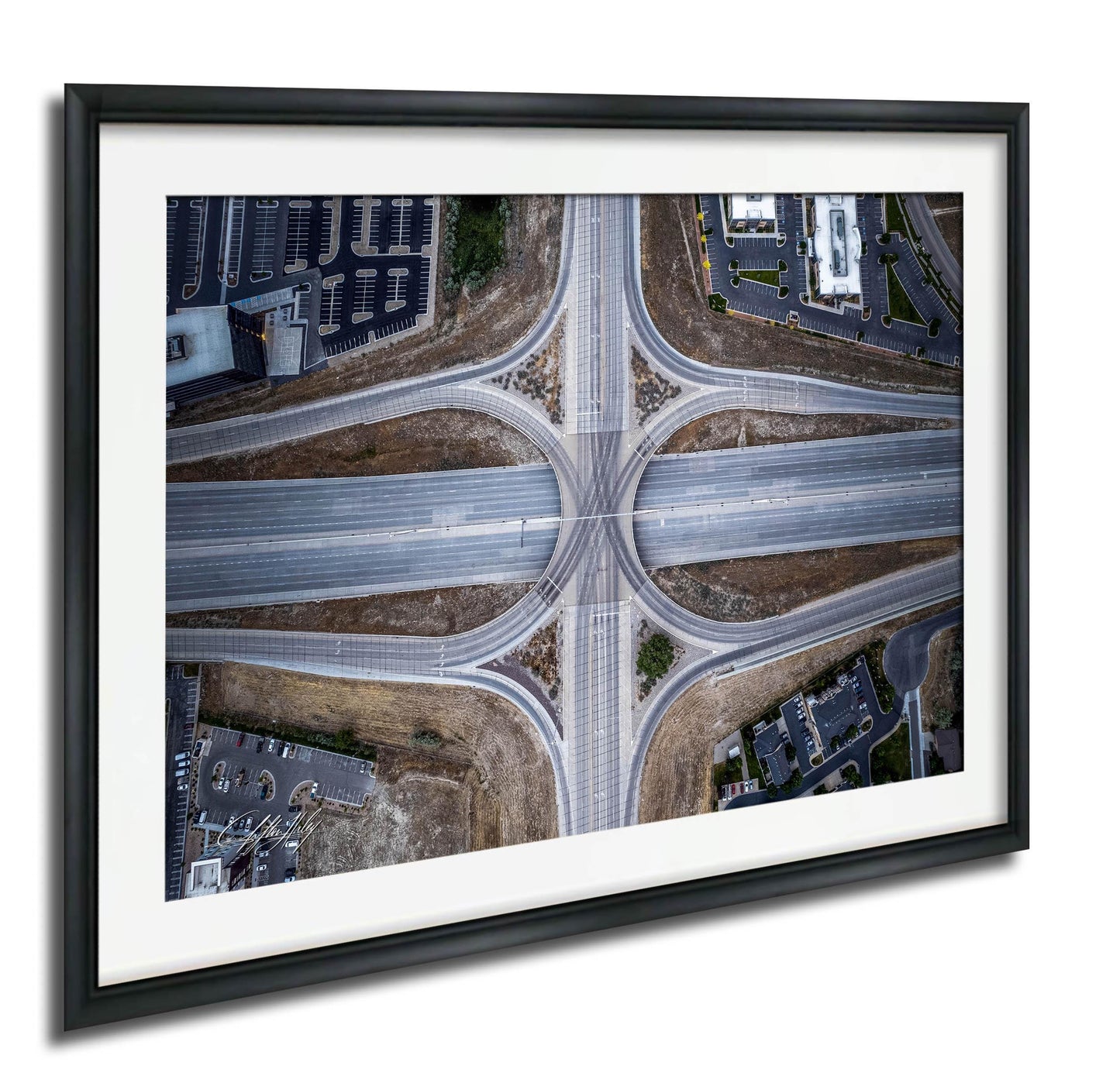 The image is an aerial view of a complex highway intersection with multiple lanes and exits, surrounded by buildings and parking lots.