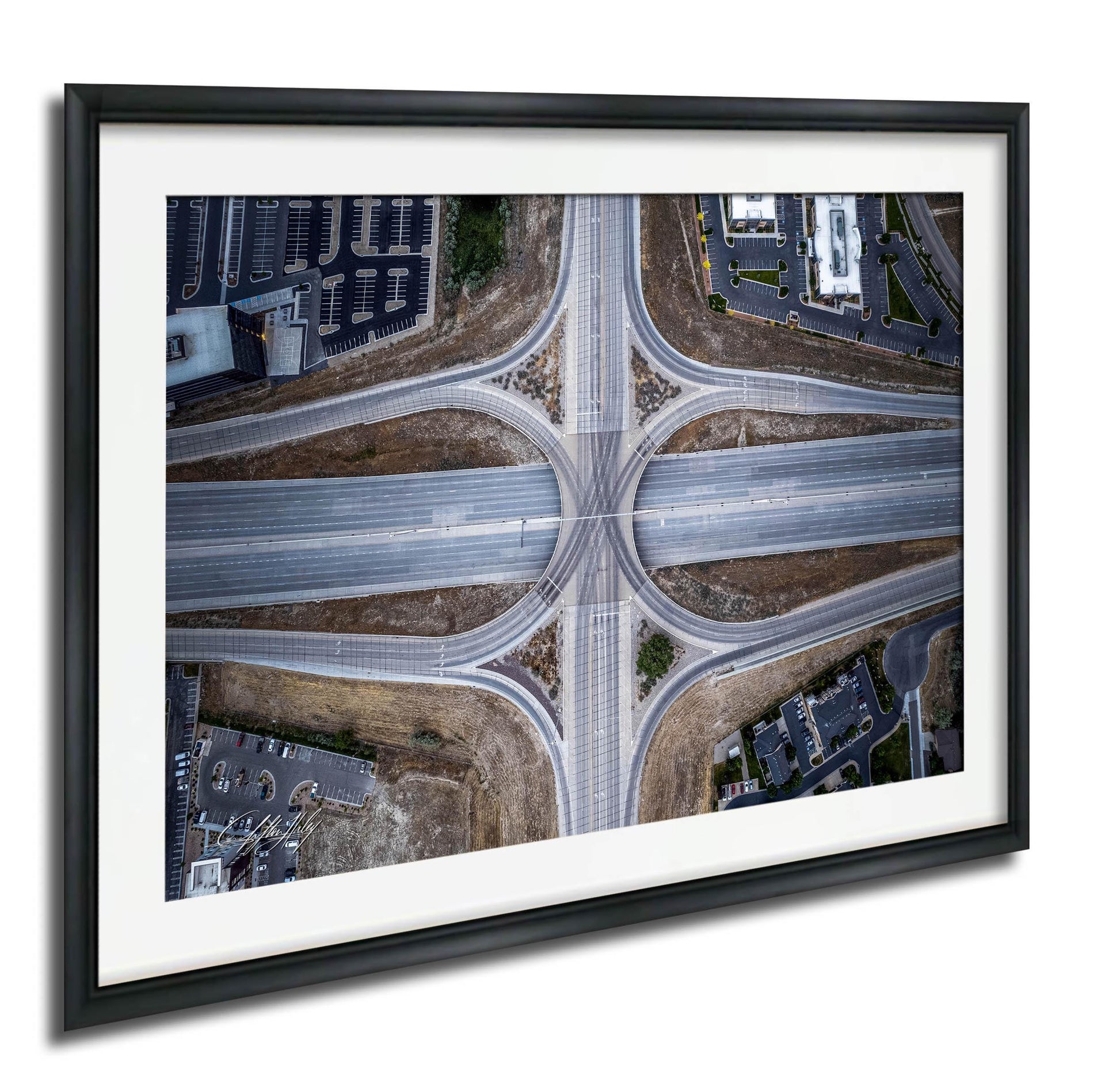 The image is an aerial view of a complex highway intersection with multiple lanes and exits, surrounded by buildings and parking lots.