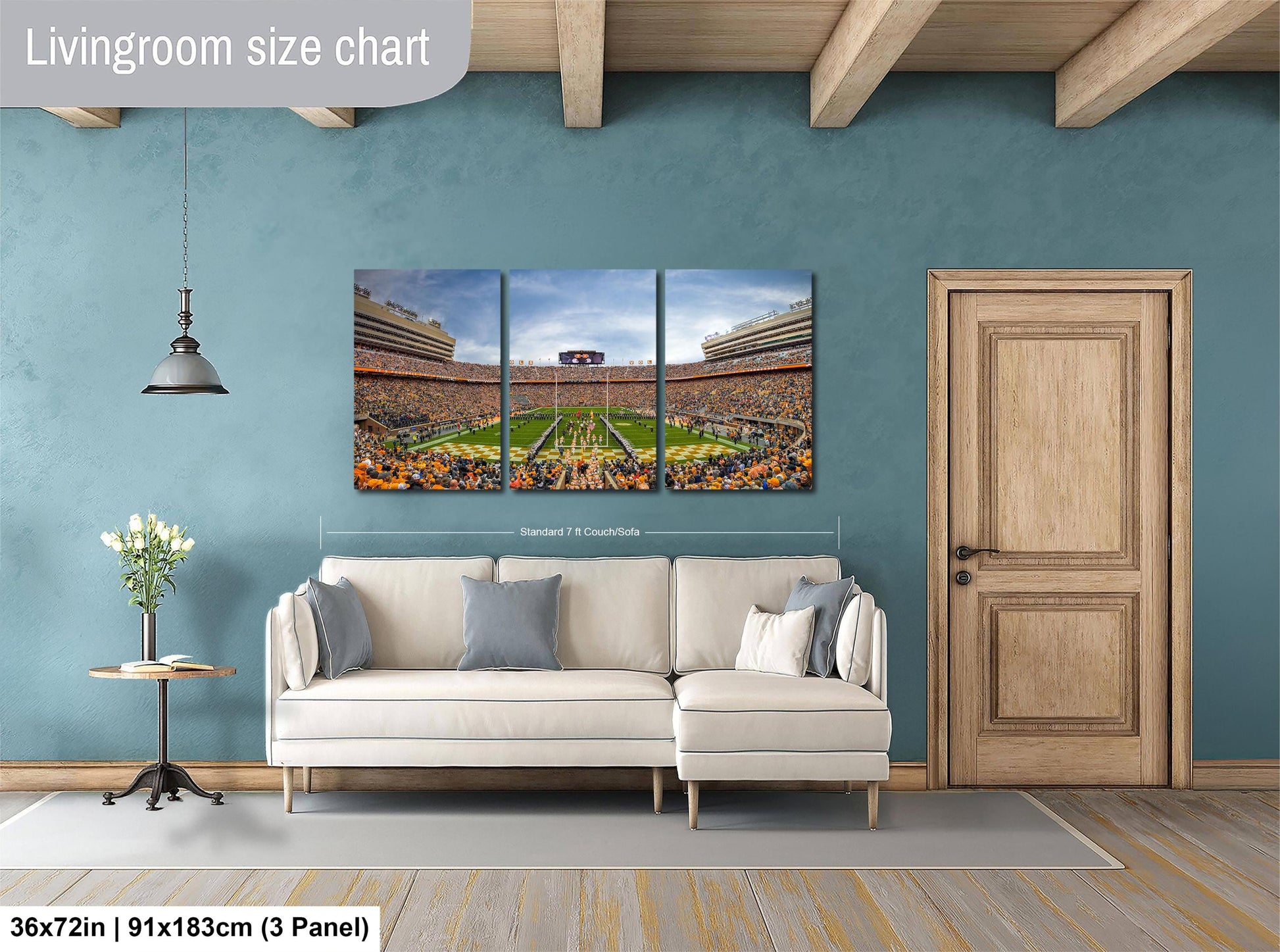 The image is a living room with a large wall art depicting a football stadium filled with spectators. The wall art is a collage of three panels, each showing different aspects of the stadium. The living room has a white sofa and a wooden door, and the floor is covered with a gray rug.