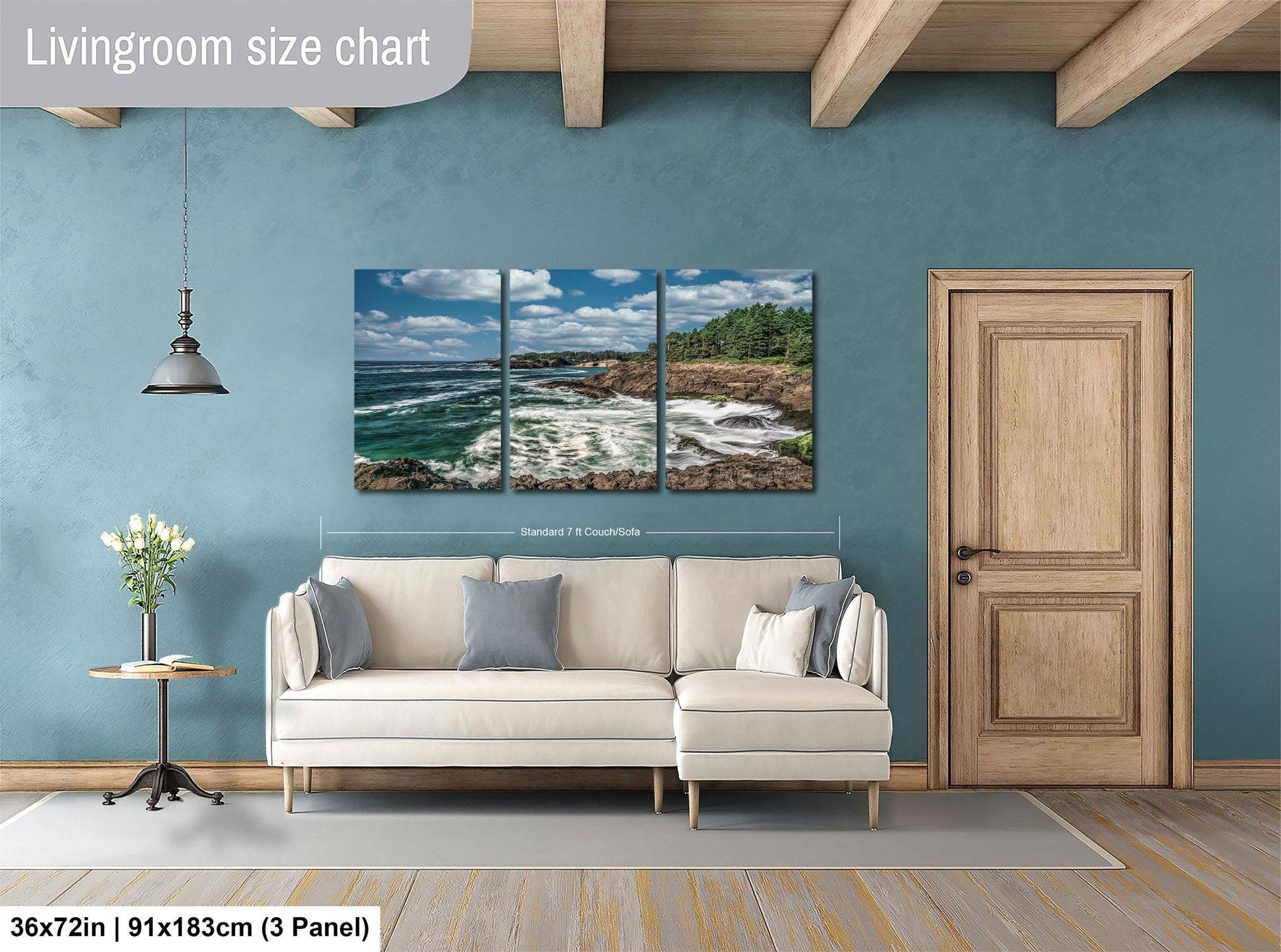 The image is a living room with a large wall art depicting a scenic ocean view. The wall art is divided into three panels, each showing a different part of the ocean landscape. The living room has a white sofa and a wooden door, creating a cozy and inviting atmosphere.