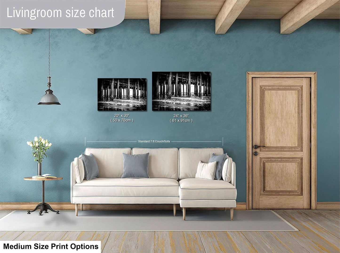 a living room with a white sofa, a wooden door, and a framed black and white photograph of a bridge hanging on the wall.