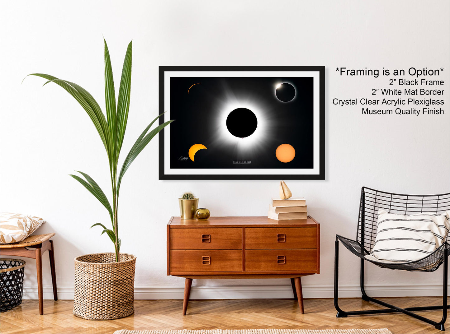 a framed poster of the solar eclipse, with a black frame and a white border, hanging on a wall above a wooden dresser with a wicker basket.