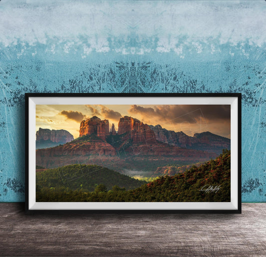The image is a framed photograph of a scenic landscape with mountains and a sunset sky.