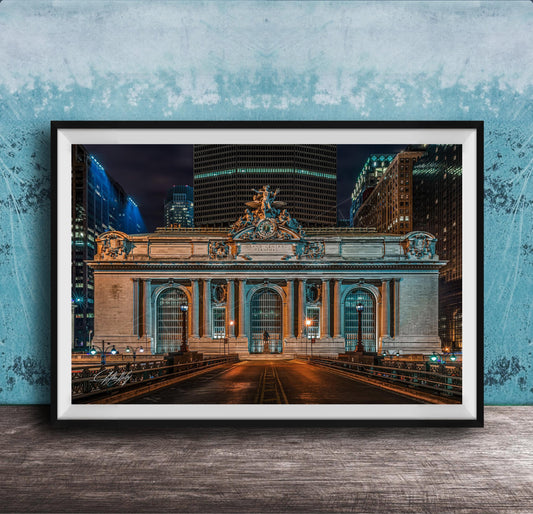 A framed photograph of the Grand Central Terminal in New York City at night, with the terminal's ornate facade and surrounding skyscrapers illuminated against a dark sky.