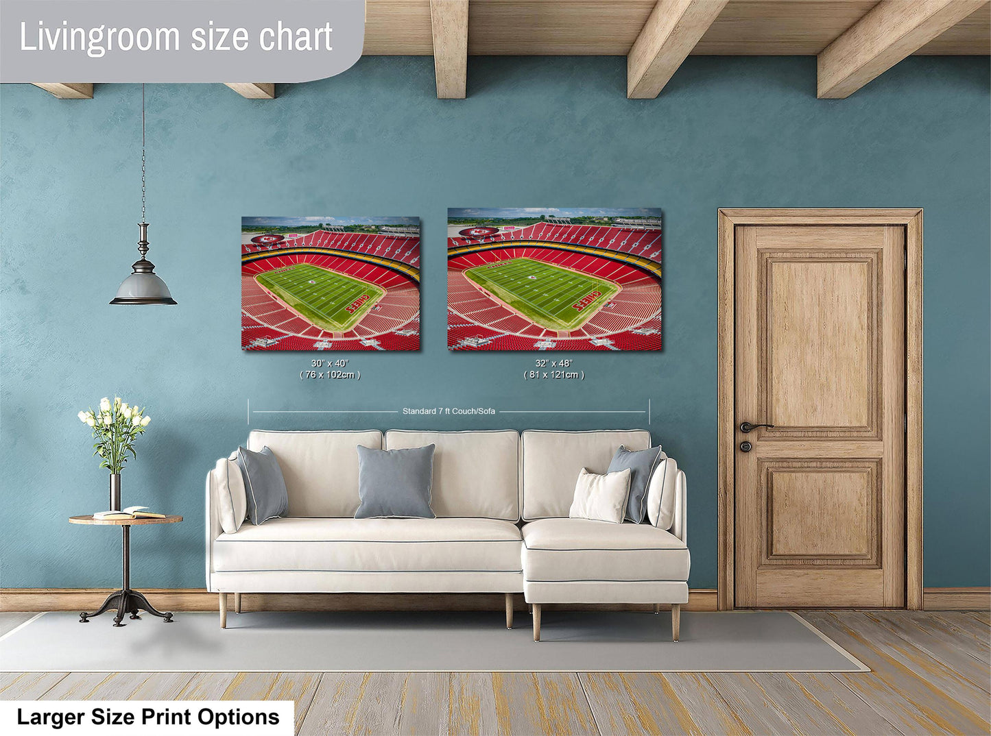 a living room with a white sofa, a wooden door, and two framed pictures of a football stadium on the wall.