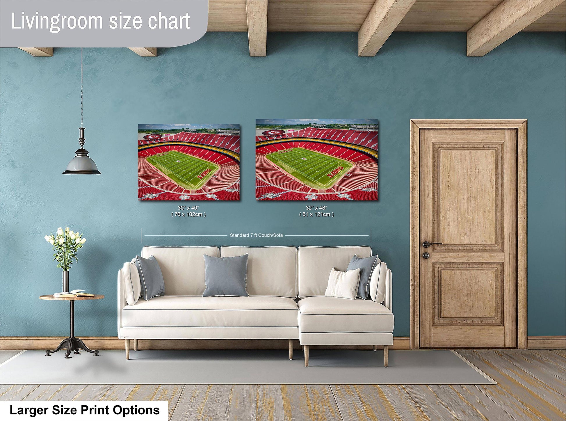 a living room with a white sofa, a wooden door, and two framed pictures of a football stadium on the wall.